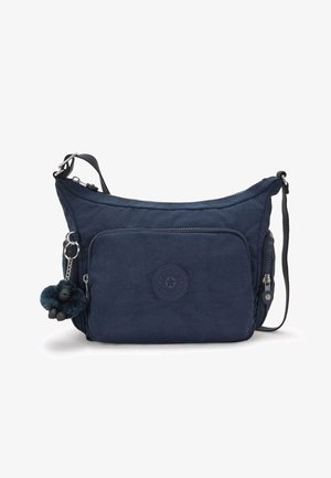 Sac bandoulière bleu marine avec poche avant zippée, fermeture latérale, sangle ajustable et un petit porte-clés singe en peluche attaché.