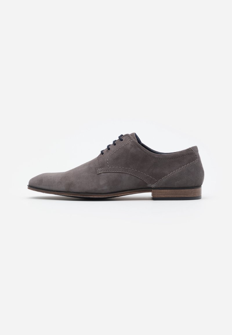 Chaussure habillée pour hommes en daim gris à lacets, avec un petit talon en bois et un design élégant à bout pointu sur fond blanc.
