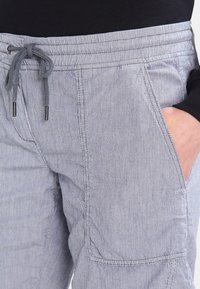 Pantalons cargo rayés bleu clair avec une taille élastique et un cordon de serrage, dotés de poches latérales et d'un tissu texturé.