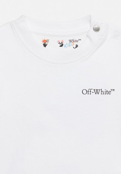Бяла детска риза Off-White с черен лого текст отпред и цветни отпечатъци на ръце вътре в яката с метален бутон на врата.