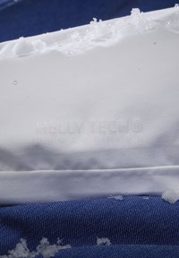 Witte stof met een reliëf logo "HELLY TECH® PROTECTION" en een blauw gestructureerd materiaal eronder; bevat sneeuwvlekken op het oppervlak.