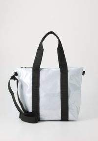 Saco tote feito de material cinza claro brilhante, com alças e ferragens pretas. Inclui uma alça de ombro preta destacável.