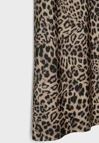 Tkanina w cętkę lamparcją z czarnymi plamami na beżowym tle; gładka tekstura; elegancko układa się bez widocznych szwów czy elementów metalowych.