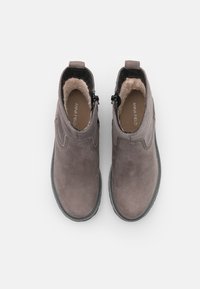 Botas de tobillo grises con un exterior de cuero suave, forro de borreguillo y cremalleras laterales. Suela de goma resistente, detalle de costura mínima.