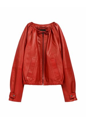 Czerwona skórzana kurtka z marszczonym dekoltem, zamkiem błyskawicznym i elastycznym dołem. Posiada dwie przednie kieszenie i mankiety na guziki. Gładka faktura.