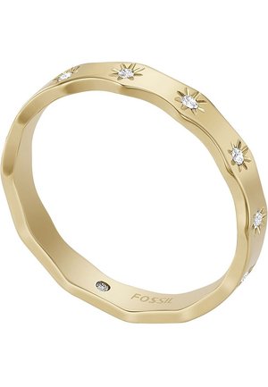 Bague dorée aux bords festonnés texturés, décorée de petits cristaux clairs disposés en motifs étoilés, estampillée "Fossil" à l'intérieur de l'anneau.