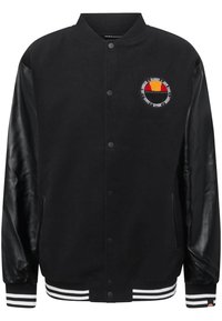 Black varsity jacket with leather sleeves, striped ribbed cuffs, and a round embroidered badge on the chest featuring red, black, and yellow.