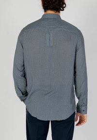 Camicia a maniche lunghe di colore blu con un motivo geometrico, caratterizzata da colletto e polsini abbottonati, realizzata in tessuto leggero.