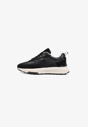 Zwarte leren sneakers met een textuurafwerking, voorzien van een crèmekleurige tussenzool, zwarte buitenzool, veters en een klein treklabel op de hiel.