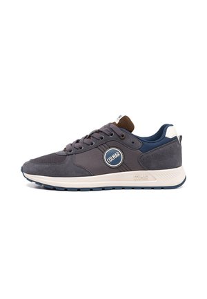 Baskets Colmar gris foncé et bleu marine avec semelle blanche, lacets et patch logo sur le côté, vues de l'extérieur.