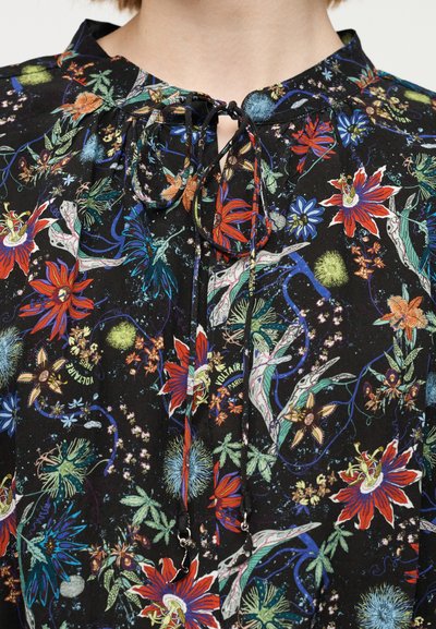 Μπλούζα από μαύρο ύφασμα με λουλουδένιο σχέδιο που περιλαμβάνει κόκκινα, μπλε και πράσινα λουλούδια. Διαθέτει σχέδιο με δέσιμο στον λαιμό και διακριτικές μεταλλικές λεπτομέρειες.