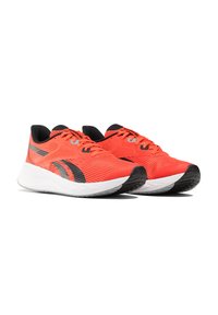 Des chaussures de sport rouges avec une tige en maille, des accents noirs, des lacets plats et une semelle blanche dotée de caoutchouc texturé pour une meilleure adhérence.