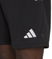 Zwarte sportshorts van lichtgewicht stof, met het witte Adidas-logo en geperforeerde accenten voor ademend vermogen en flexibiliteit.