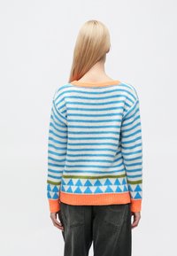 Sweter dziergany z poziomymi niebiesko-białymi paskami, z pomarańczowym dekoltem i trójkątnym wzorem w zieleni i niebieskim na dole.