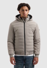 Lichtgrijze gewatteerde jack met een ritssluiting en capuchon. Heeft ribgebreide manchetten en zoom met zwarte accenten, een getextureerd oppervlak en logo-detail.