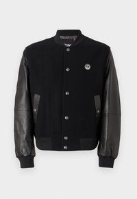 Jachetă varsity neagră cu corp din lână și mâneci din piele, având un închidere cu nasturi snap, buzunare laterale și un patch rotund cu logo pe piept.