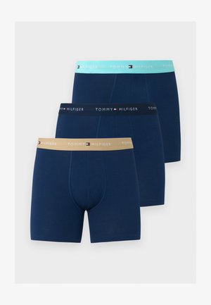 Drei Paare marineblaue Boxershorts mit Tommy Hilfiger gebrandeten Bündchen in Beige, Schwarz und Hellblau.