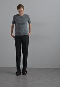 Gray short-sleeve knit top paired with black high-waisted trousers, featuring a straight cut and minimalistic design. Smooth texture and clean lines.