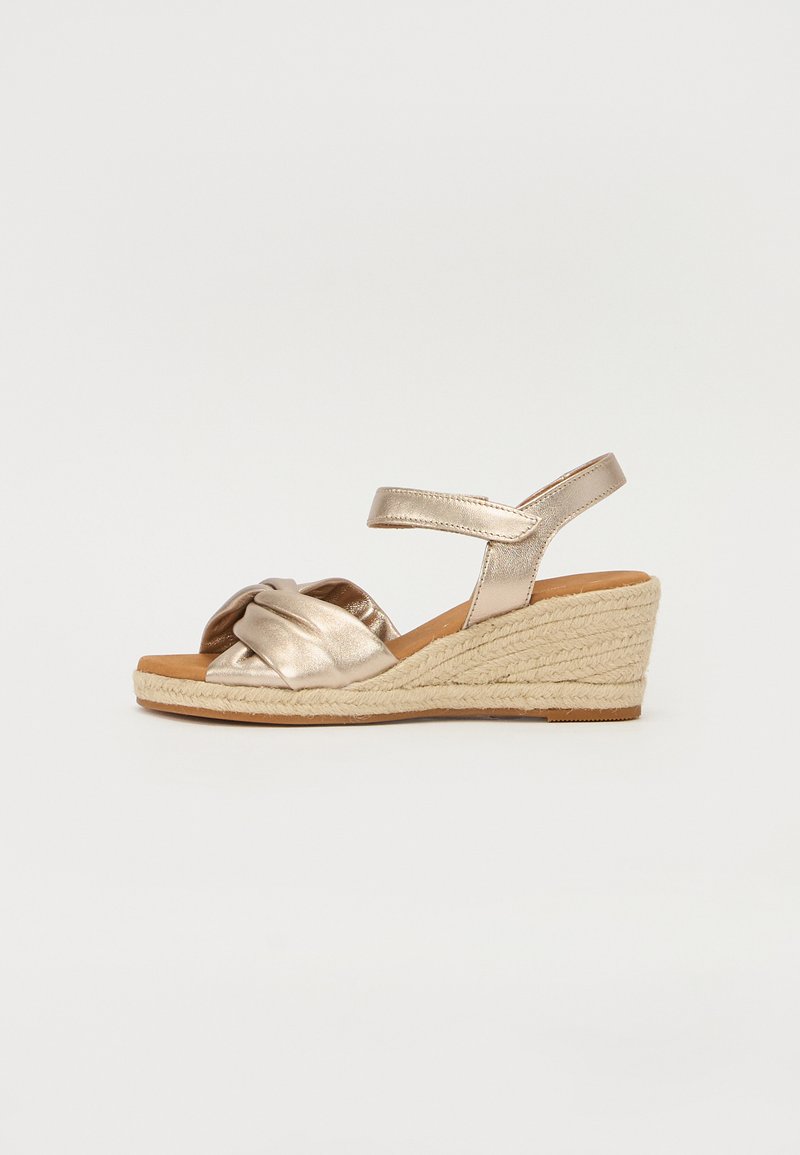Metallic gold espadrille wedge sandals with a knotted design, textured fabric straps, and a jute-wrapped midsole.