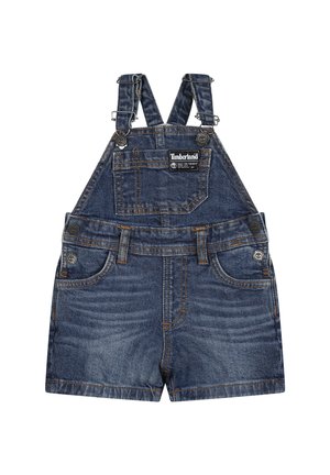 Salopette en denim bleu foncé avec des bretelles réglables, une poche frontale, deux poches latérales et des coutures orange. Présente une étiquette avec le logo Timberland.