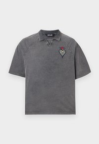 Γκρι κοντομάνικο πόλο με μικρό κεντητό σχέδιο καρδιάς και λουλουδιού στο αριστερό στήθος και διακριτική υφή πλυσίματος.