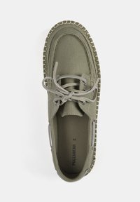 Bottines en toile vert olive avec un bout arrondi, une tige texturée, des lacets gris et une semelle en caoutchouc à motif. Taille 42 affichée à l'intérieur.