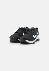Black athletic shoes with a textured surface, white accents, and a logo. Features a cushioned sole and lace-up design.