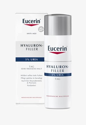 Eucerin Hyaluron-Filler Anti-Aging-Creme in einer weißen zylindrischen Flasche mit silberner Kappe; die Verpackung weist blaue und rote Akzente auf; 5% Harnstoff.
