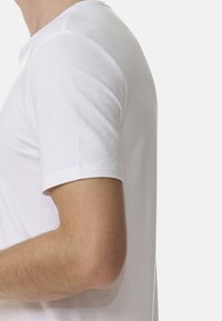 Biała bawełniana koszulka z okrągłym dekoltem i krótkimi rękawami, gładka tekstura i dopasowany krój, widoczne detale szwów przy rękawach.