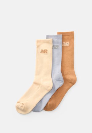 Tre ribbede crew-sokker i beige, lyseblå og brun, hver med et lille "NB"-logo nær den øverste kant.