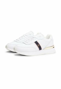 Sneaker bianche con una finitura in pelle liscia, dotate di una striscia blu navy e un accento dorato sul tallone. Le suole sono testurizzate per una migliore aderenza.