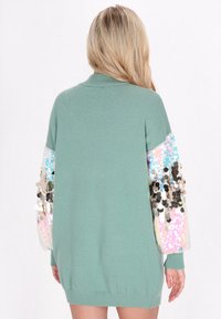 Lange mouw gebreide trui in mintgroen met glinsterende paillettenmouwen in meerdere kleuren, met een relaxte pasvorm en geribbelde zoom.