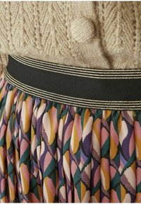 Gonna a pieghe con tessuto decorato in tonalità di rosa, verde e giallo, caratterizzata da una fascia in vita nera con doppie strisce dorate.