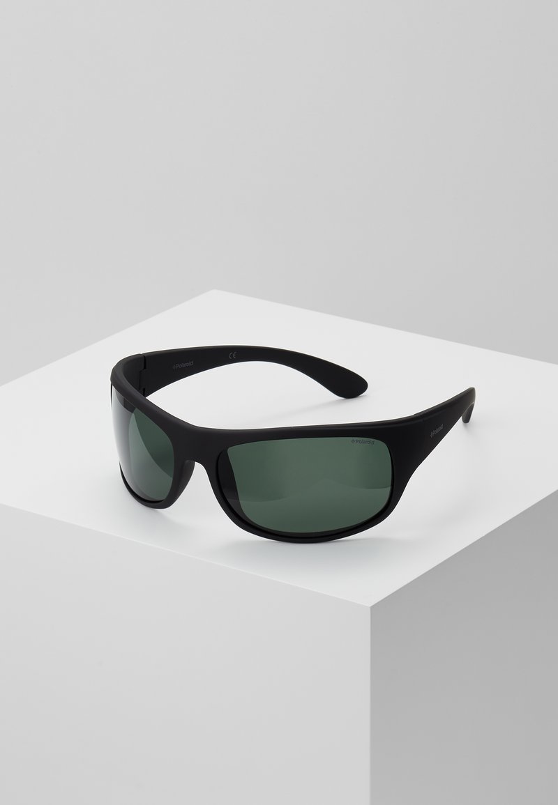 Ochelari de soare sport negri cu lentile verzi, design wraparound și finisaj mat. Dispune de o ramă ușoară pentru confort.