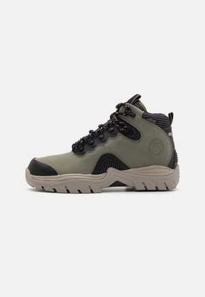 High-top hiking boots in olive green and black. Features a textured upper, reinforced toe cap, and rugged rubber outsole for traction.