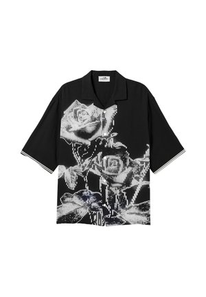 Musta lyhythihainen nappipaita, jossa on rohkea valkoinen, pikselöity kukkakuvio ja hihansuissa hillitty raidallinen reunus.