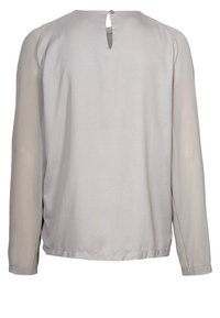 Långärmad blus i ljusgrått med en slät textur, genomskinliga ärmar, rundad halsringning och en nyckelhål detailj på baksidan.