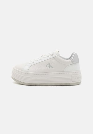 Valged platvormiksed sneakerid, millel on kivikujuline tekstuur, hõbedane aktsent ja paelad ning Calvin Kleini logo küljes. Kummist tald.