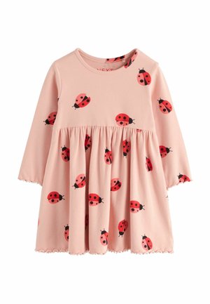 Robe enfant rose à manches longues décorée d’imprimés coccinelles rouges et noires, taille froncée et poignets et ourlet légèrement volantés.