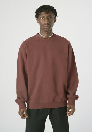 Maroon sweatshirt with a crew neckline and ribbed cuffs. Features a small embroidered bird logo on the chest. Soft cotton blend material.