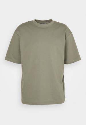 Olive green oversized t-shirt made of cotton, featuring a round neckline, short sleeves, and side slits for a relaxed fit.