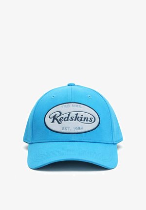 Casquette de baseball bleu vif avec un patch ovale blanc à l'avant affichant "Redskins" en écriture noire et "EST. 1984" en dessous.