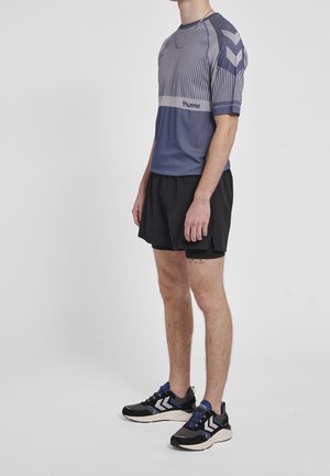 Conjunto deportivo que incluye una camiseta de manga corta a rayas en azul y gris, pantalones cortos negros y zapatillas negras con detalles en azul.