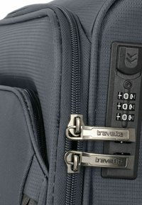 Maleta de viaje gris con material texturizado, doble cremallera de metal y un candado de combinación en el lateral para mayor seguridad.