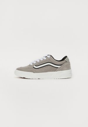 Suede sneakers in gray with white laces and a black accent. Features a rubber sole, side logo, and stitched detailing on the upper.