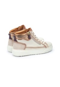 Zapatillas altas en cuero beige con acabado texturizado, detalles metálicos, cierre lateral y suelas de goma blanca. Presenta un interior acolchado marrón.
