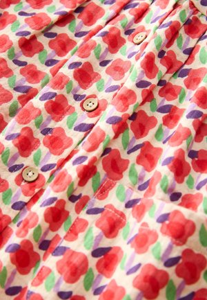 Stoff mit Blumenmuster, das rote Blumen, grüne Blätter und violette Akzente zeigt. Die Knöpfe sind hellbraun mit leicht glänzendem Finish.