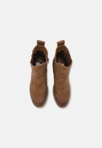 Braune Leder-Stiefeletten mit glatter Oberfläche, runden Zehen und seitlichen Reißverschlüssen. Mit einem Zugtab und einem gemusterten Innenfutter.