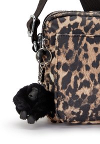 Borsa a tracolla con stampa leopardata e hardware nero; presenta un portachiavi a forma di gorilla peloso attaccato per un tocco in più. Includa una tracolla regolabile.