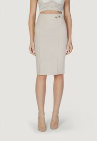 Falda lápiz beige con cintura alta, cuenta con dos botones decorativos dorados en la cintura, tejido suave y ajuste entallado.